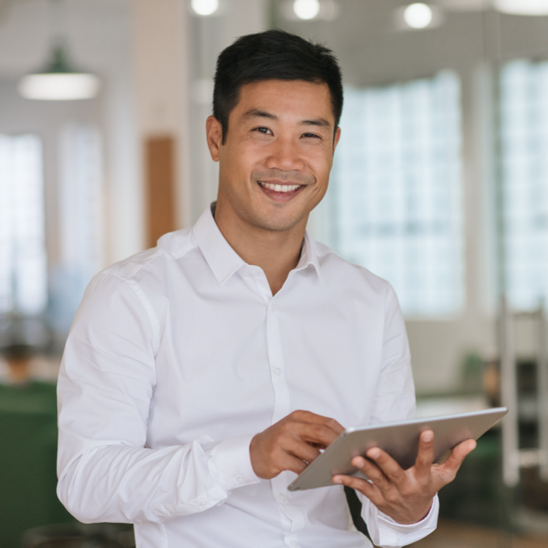 A male looking at the camera with a tablet in hand